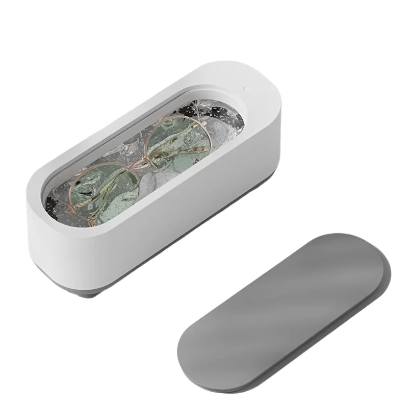 Dispositivo pulizia occhiali ad ultrasuoni bianco, coperchio grigio, design moderno, ideale per lenti e gioielli. Accessorio casa essenziale.
