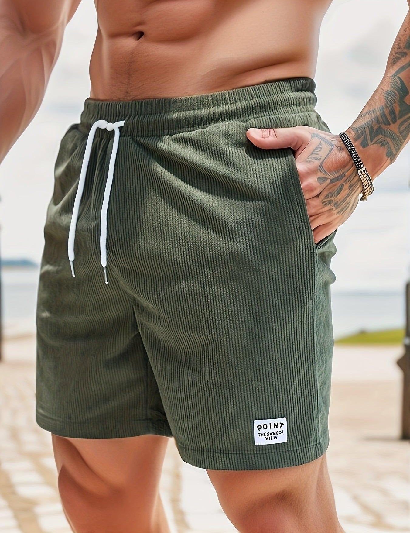 Shorts da uomo verde oliva a coste, con laccio bianco in vita e tasche laterali. Ideali per moda estiva e look casual.