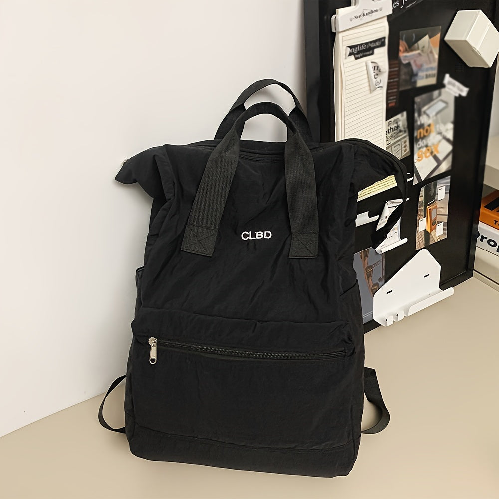 Zaino nero CLBD su scrivania, design minimalista, tasca frontale con zip, ideale per scuola o lavoro. Accessorio moda unisex.