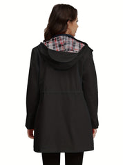 Donna con cappotto nero impermeabile, cappuccio foderato a quadri, vista posteriore. Moda autunnale, abbigliamento casual elegante.