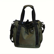 Borsa a tracolla verde oliva con manici neri, tasche laterali e chiusura a coulisse. Design moderno, ideale per viaggi e uso quotidiano.