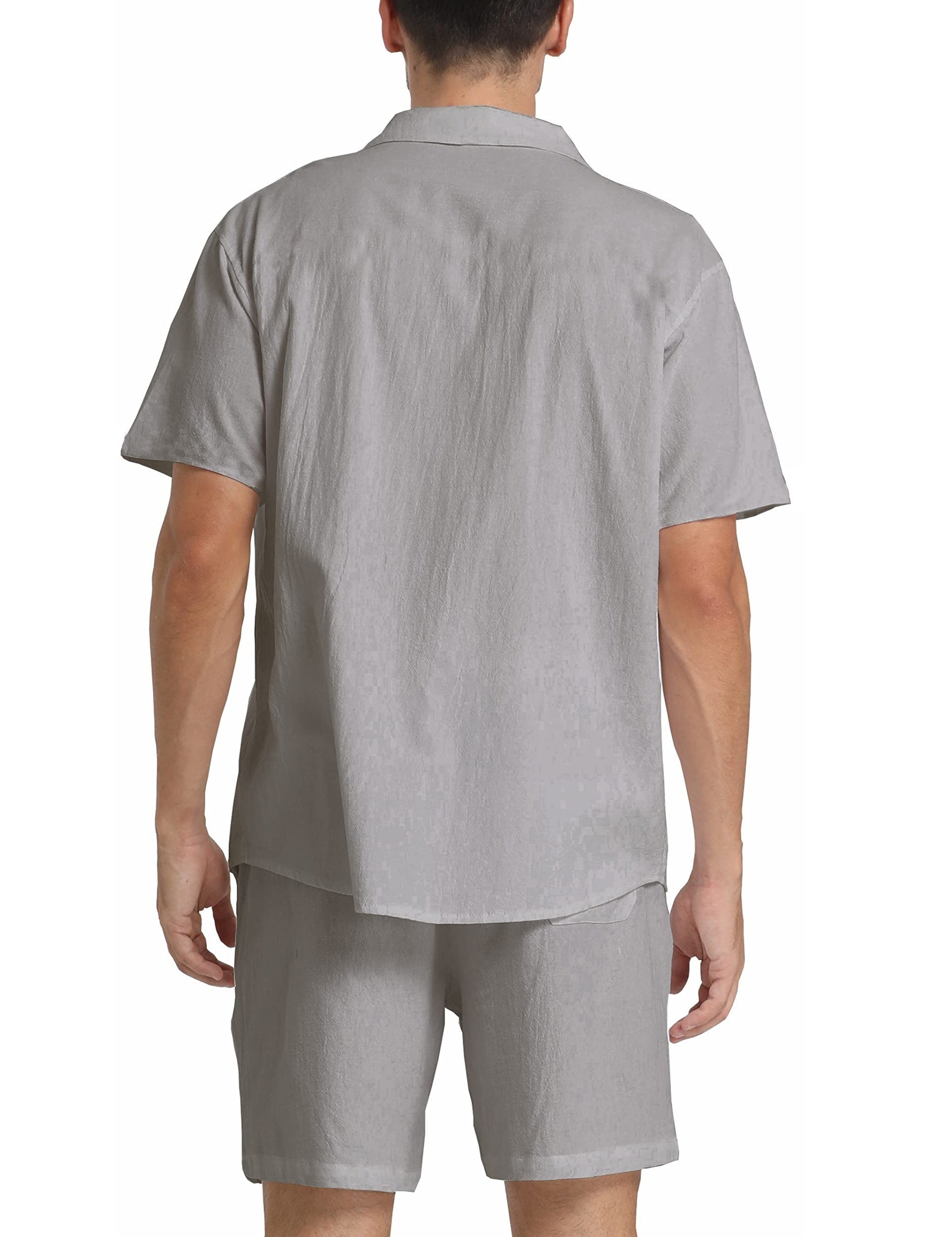 Uomo in completo estivo grigio chiaro, camicia a maniche corte e pantaloncini coordinati, moda casual, tessuto leggero, vista posteriore.