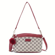 Borsa a tracolla elegante in pelle rossa e tessuto stampato, con ciondolo pompon. Design moderno, ideale per moda donna e accessori di tendenza.