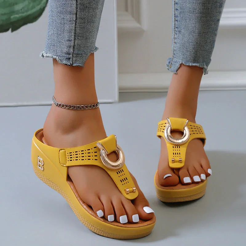 Sandali gialli con zeppa, cinturino decorativo, indossati con jeans. Scarpe estive moda donna, comode e trendy, perfette per look casual.