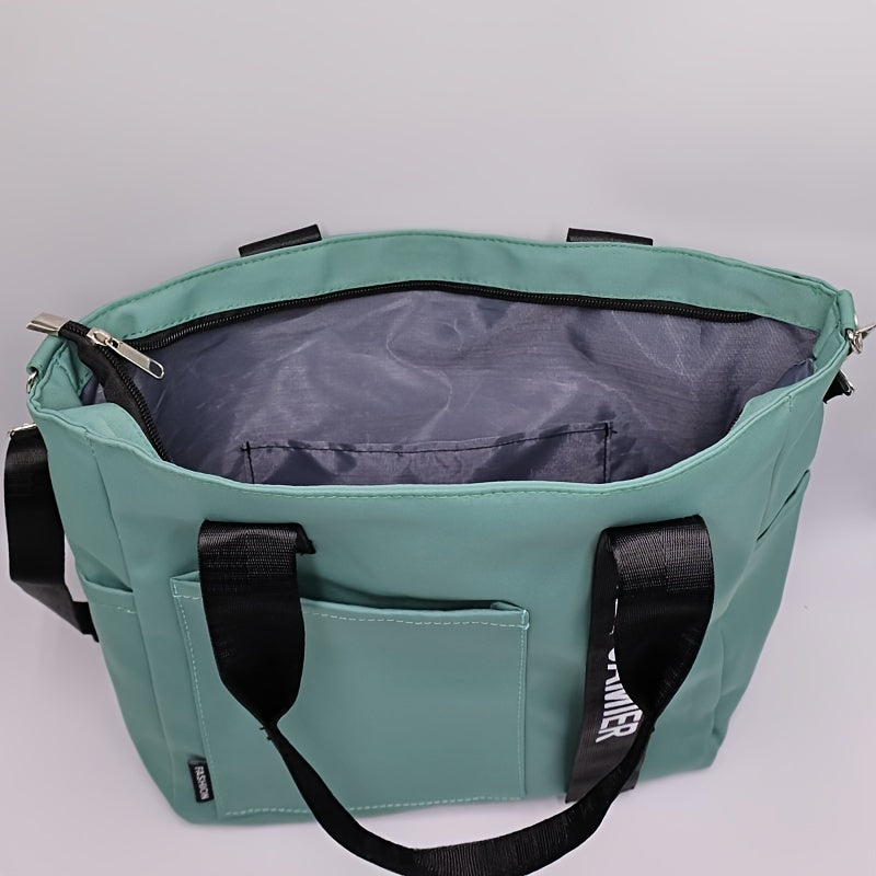Borsa tote verde acqua con manici neri, tasca frontale e chiusura a zip. Design moderno, ideale per shopping e uso quotidiano.