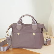 Borsa a tracolla in nylon grigio con manici, tasche esterne e dettagli dorati, ideale per moda donna, accessori eleganti e versatili.