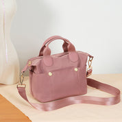 Borsa a tracolla rosa in tessuto, design elegante con manici e tasche frontali, ideale per moda femminile e uso quotidiano.