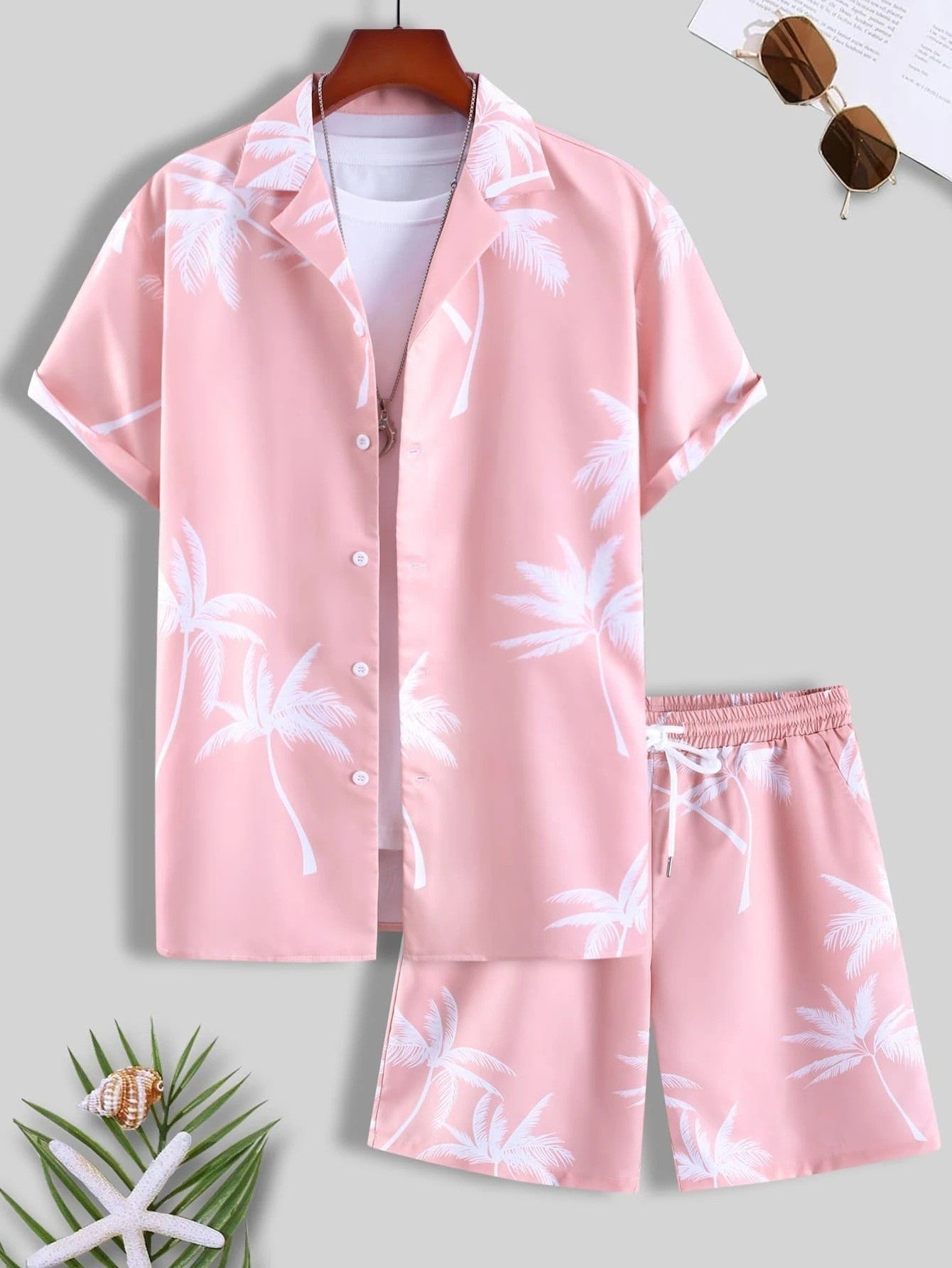 Completo estivo uomo rosa con palme bianche, camicia a maniche corte e pantaloncini coordinati. Perfetto per look casual e vacanze.