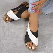 Sandali donna estivi bianchi e neri, design incrociato, suola in legno, indossati con jeans. Scarpe moda casual eleganti e comode.