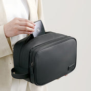 Donna inserisce un dispositivo elettronico in un elegante beauty case nero in pelle, ideale per viaggi, accessori moda, organizzazione bagagli.