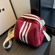 Borsa a tracolla rossa con strisce bianche, design moderno, chiusura con zip, cinturino regolabile beige, ideale per moda casual e urbana.