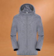 Giacca impermeabile grigia con cappuccio, chiusura a zip, design moderno su sfondo marrone. Abbigliamento outdoor, moda autunnale, giacca antivento.