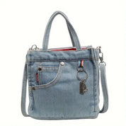 Borsa a tracolla in denim blu con manici, tasca frontale, cerniera superiore e portachiavi. Design casual e versatile per ogni occasione.
