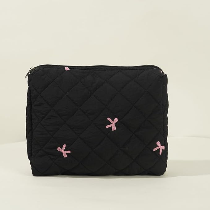 Borsa nera trapuntata con cerniera, decorata con fiocchi rosa. Accessorio moda elegante, ideale per organizzare oggetti personali.
