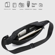 Marsupio nero aperto con scomparti, contenente smartphone, libro e tablet. Design moderno, ideale per viaggi e uso quotidiano. Tasche multiple.