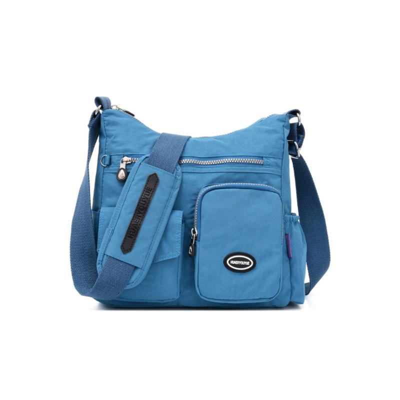 Borsa a tracolla blu in nylon con tasche multiple, cerniere e logo frontale. Design casual e pratico, ideale per uso quotidiano e viaggi.