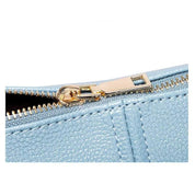 Chiusura lampo dorata su borsa in pelle blu chiaro, texture elegante. Accessorio moda donna, dettagli di lusso, design moderno.