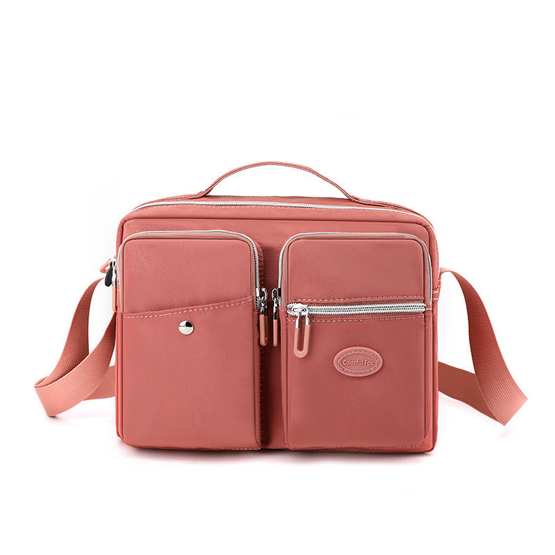 Borsa a tracolla rosa in pelle sintetica con tasche multiple e cerniere, design elegante e pratico per donna, ideale per uso quotidiano.