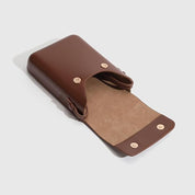 Custodia in pelle marrone per occhiali, design elegante e minimalista, chiusura a bottone, accessorio moda, protezione occhiali da sole.
