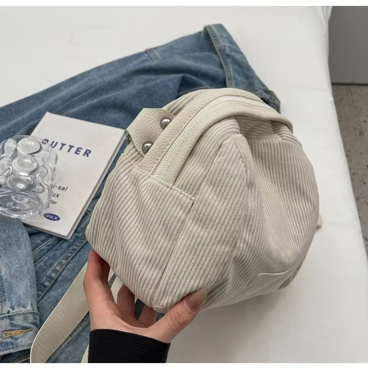 Zaino in velluto a coste bianco su giacca di jeans, design casual, moda urbana, accessorio trendy per donna, perfetto per uso quotidiano.