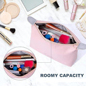 Astuccio trucco rosa con grande capacità, contenente rossetti, pennelli e cosmetici su sfondo marmo. Accessori bellezza, organizzazione trucco.