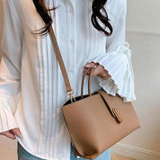 Camicia bianca elegante con maniche a pieghe, abbinata a borsa a tracolla marrone in pelle. Moda donna, abbigliamento casual chic.