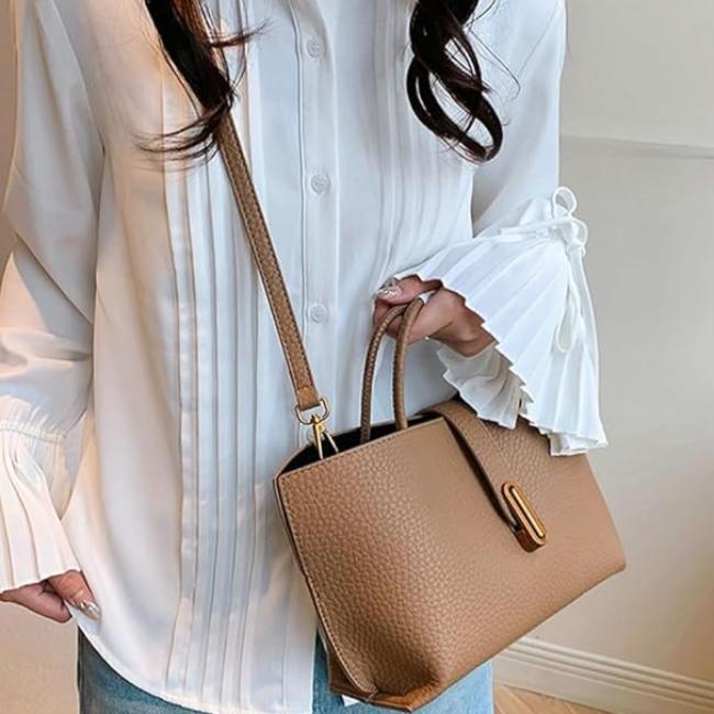 Camicia bianca elegante con maniche a pieghe, abbinata a borsa a tracolla marrone in pelle. Moda donna, abbigliamento casual chic.