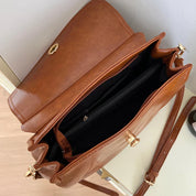 Borsa a tracolla in pelle marrone con chiusura dorata, scomparti interni spaziosi e tracolla regolabile. Elegante accessorio moda donna.