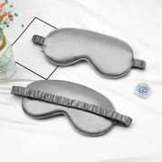 Maschera per dormire in seta grigia su sfondo bianco, con elastico arricciato. Accessorio relax, ideale per migliorare il sonno e ridurre la luce.