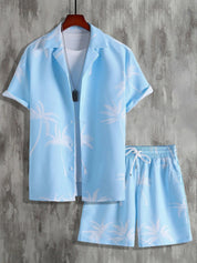 Completo estivo uomo azzurro con palme, camicia a maniche corte e pantaloncini coordinati. Moda casual, ideale per vacanze e look estivi.
