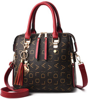 Borsa a mano elegante in pelle nera con dettagli rossi, ciondolo a forma di gatto, tracolla regolabile, design con lettere dorate.