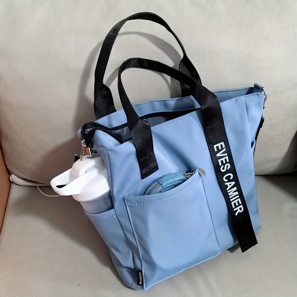 Borsa tote azzurra con manici neri, tasche esterne e bottiglia d'acqua bianca. Design moderno, ideale per shopping e uso quotidiano.