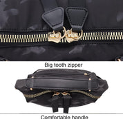 Zaino nero con cerniera a denti grandi e manico comodo, design mimetico, dettagli in metallo dorato, ideale per viaggi e uso quotidiano.