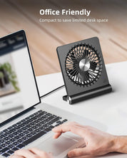 Ventilatore da scrivania compatto nero, design moderno, USB, ideale per ufficio, risparmio spazio, silenzioso, posizionato accanto a un laptop.