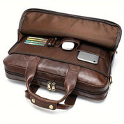Borsa ventiquattrore in pelle marrone con scomparti organizzati, contenente penne, mouse, smartphone. Ideale per lavoro e viaggi d'affari.