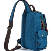Zaino monospalla in tela blu con tasche multiple, cerniere robuste e tracolla regolabile. Ideale per viaggi, escursioni e uso quotidiano.