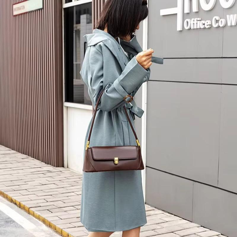 Cappotto donna blu elegante, borsa a tracolla marrone, moda autunnale, strada urbana, look casual chic, abbigliamento femminile moderno.