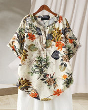 Camicia donna floreale in cotone, maniche corte, sfondo bianco, motivi tropicali colorati, perfetta per estate, moda casual, abbigliamento leggero.