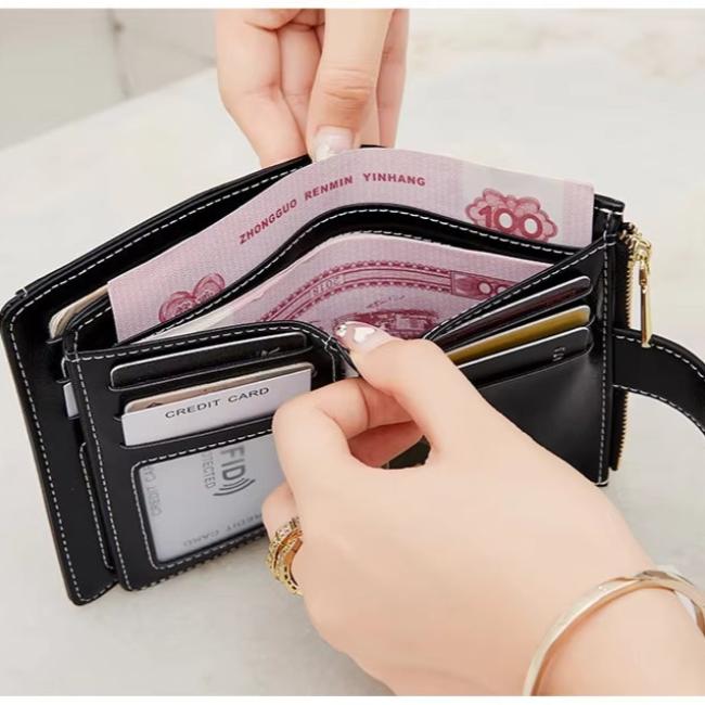 Portafoglio nero in pelle con cerniera, carte di credito e banconote cinesi. Design elegante, compatto e funzionale per uso quotidiano.