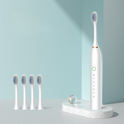 Spazzolino elettrico bianco con quattro testine di ricambio su base, design moderno, setole morbide, ideale per igiene orale quotidiana.