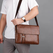 Borsa a tracolla in pelle marrone per uomo, elegante e pratica, indossata su camicia bianca. Accessorio moda maschile, ideale per lavoro e viaggio.