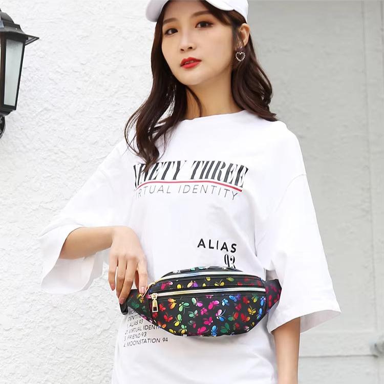 Donna con marsupio floreale, indossa t-shirt bianca e cappello. Moda casual, accessori colorati, street style. Sfondo bianco.