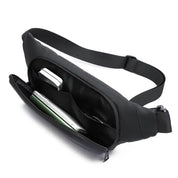Marsupio nero in tessuto impermeabile con cerniera aperta, scomparti interni e oggetti come smartphone e penna. Accessorio moda pratico e versatile.
