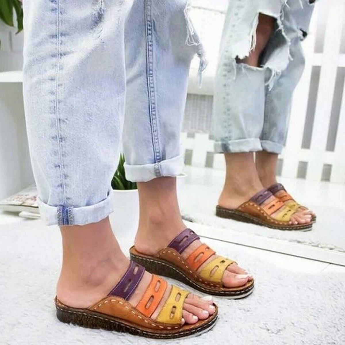 Sandali multicolore in pelle con zeppa, indossati da una persona con jeans strappati. Scarpe estive comode, moda casual, calzature donna.