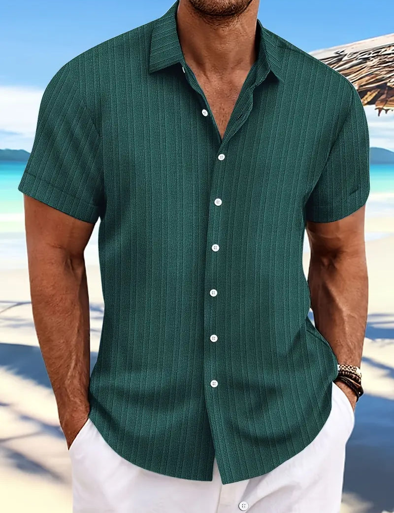 Camicia estiva da uomo verde a righe, maniche corte, sfondo spiaggia. Ideale per moda mare, look casual elegante.