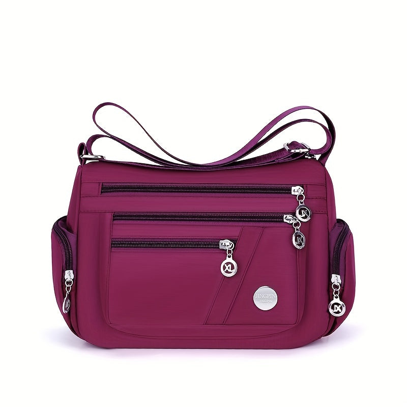Borsa a tracolla viola con tasche multiple e cerniere, design elegante e funzionale, ideale per donna. Accessorio moda versatile e pratico.