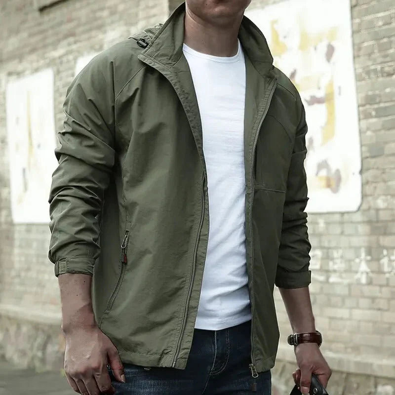 Giacca verde militare da uomo, stile casual, con zip, indossata su maglietta bianca. Ideale per moda urbana e abbigliamento primaverile.