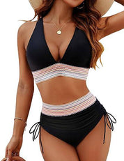 Donna in bikini nero a vita alta con dettagli a righe, cappello di paglia e collana dorata. Moda mare estiva, costumi da bagno eleganti.