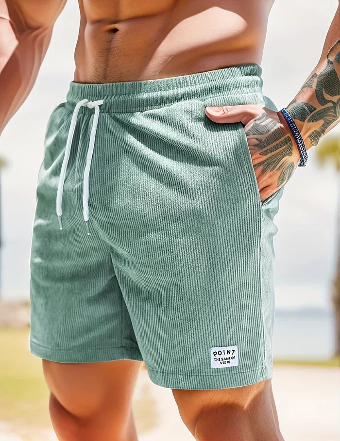 Shorts da uomo in tessuto a coste verde menta, con laccio bianco in vita e tasche laterali. Ideali per l'estate e il tempo libero.