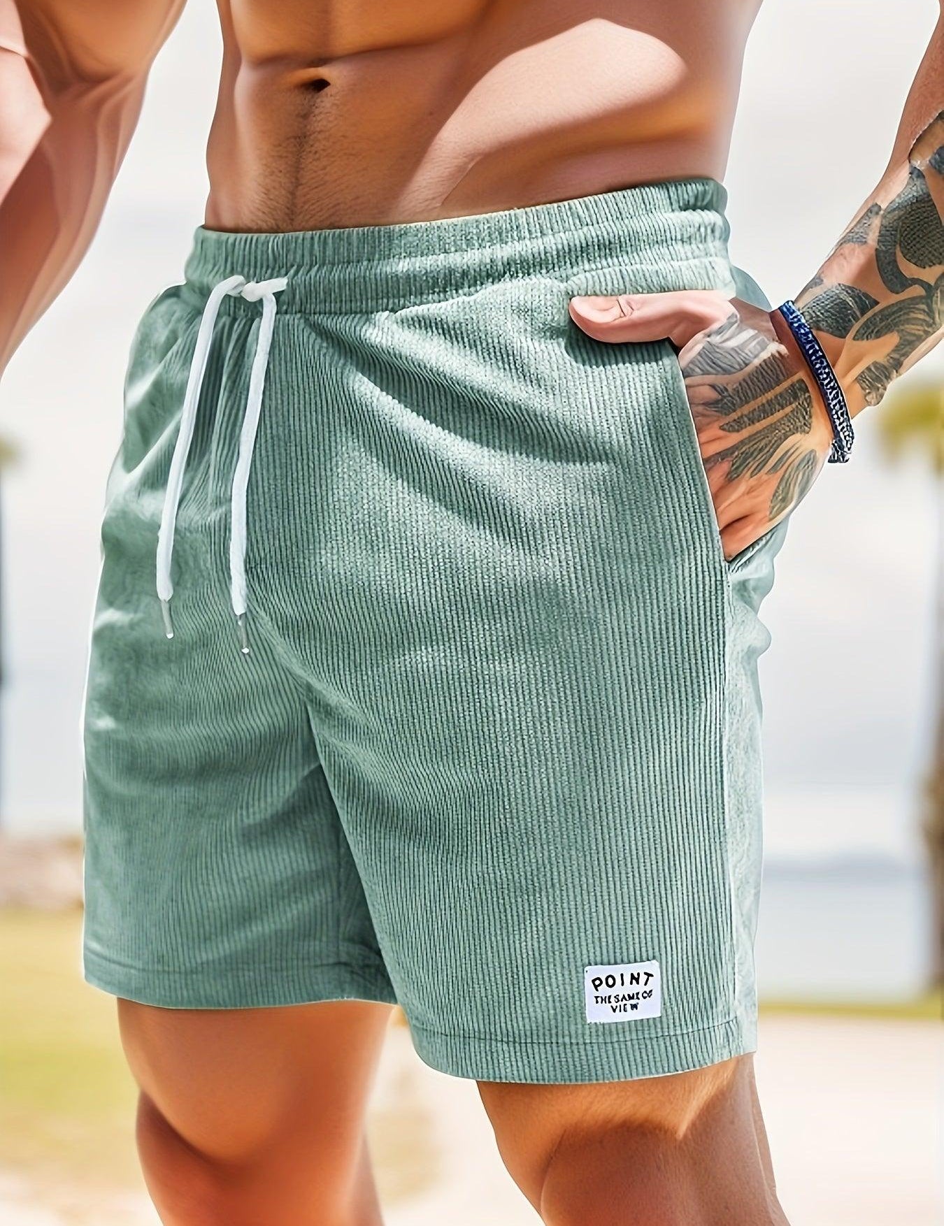 Shorts da uomo in tessuto verde a righe, con laccio bianco in vita e tasche laterali. Ideali per l'estate e il tempo libero.